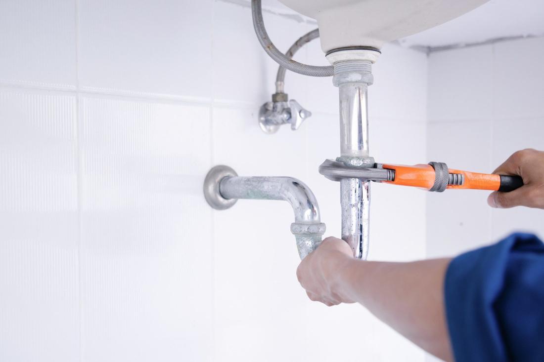 Plombier intervenant sur le siphon d'un lavabo