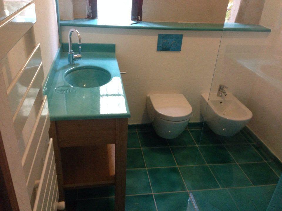 Vue d'ensemble de la salle de bains turquoise avec meuble bois et vasque en verre
